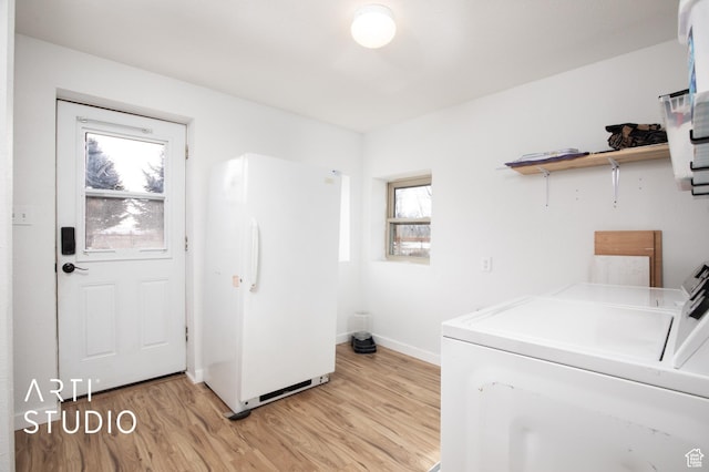laundry area featuring separate washer and dryer and light hardwood / wood-style flooring