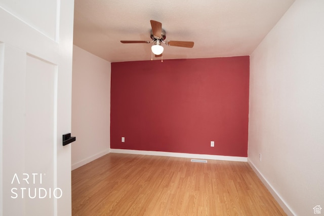 empty room featuring ceiling fan, light hardwood / wood-style floors, and a textured ceiling