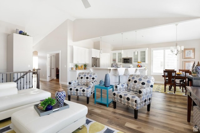 living room featuring hardwood / wood-style floors, high vaulted ceiling, and an inviting chandelier