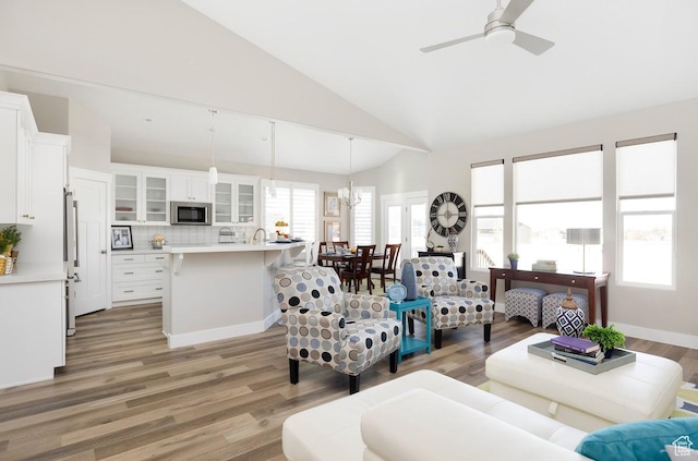 living room featuring hardwood / wood-style floors, ceiling fan, and high vaulted ceiling