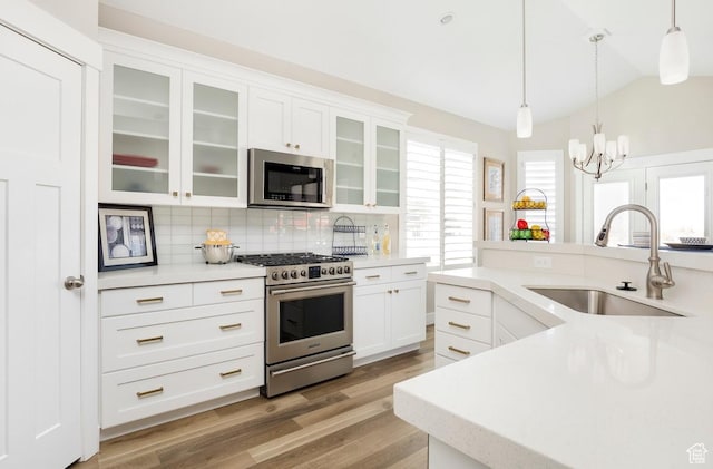 5129 N Cambridge Way, Stansbury Park, UT 84074 - kitchen featuring stainless steel appliances, a sink, decorative backsplash, light countertops, and vaulted ceiling