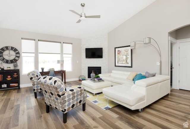 5129 N Cambridge Way, Stansbury Park, UT 84074 - living room featuring lofted ceiling, wood finished floors, ceiling fan, arched walkways, and a fireplace