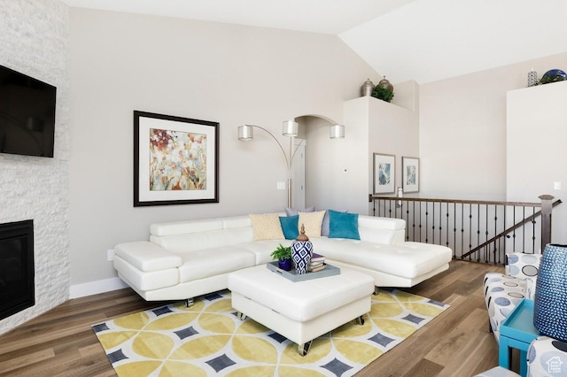 living room featuring a fireplace, dark hardwood / wood-style flooring, and high vaulted ceiling