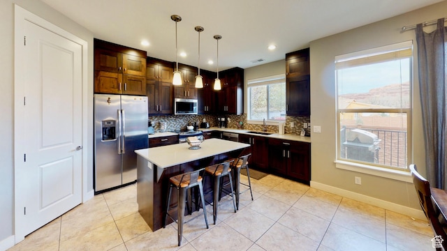 668 W 0470 N, Moab, UT 84532 - kitchen featuring tasteful backsplash, stainless steel appliances, a center island, hanging light fixtures, and a breakfast bar area