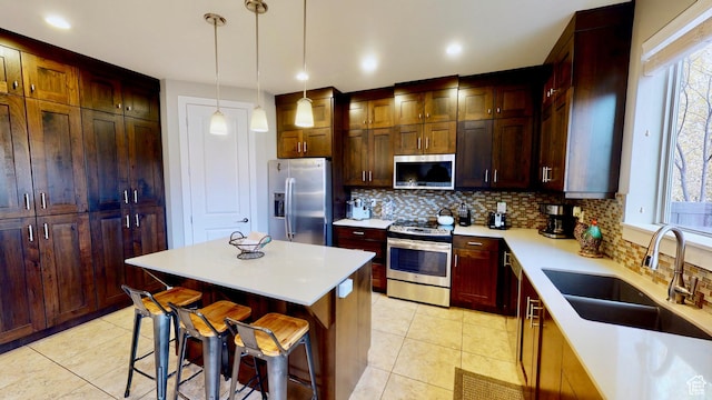 668 W 0470 N, Moab, UT 84532 - kitchen with stainless steel appliances, sink, decorative light fixtures, a kitchen island, and a breakfast bar area