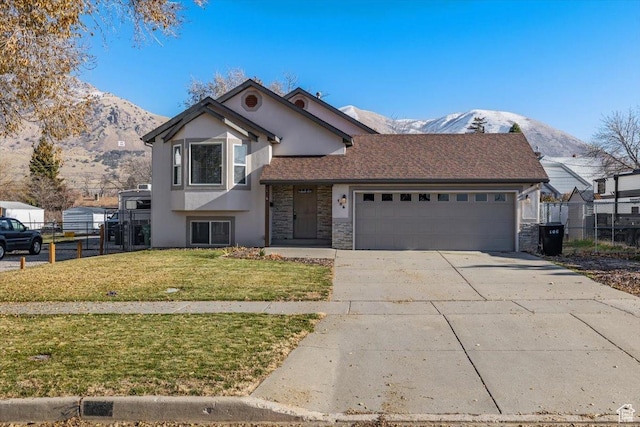 view of front of house with a mountain view, a garage, and a front lawn