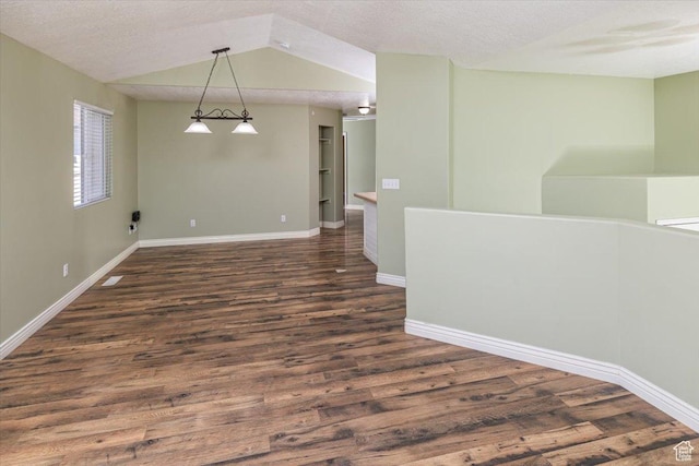 empty room with a textured ceiling and dark wood-type flooring