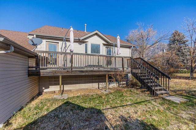 rear view of house featuring a lawn and a deck