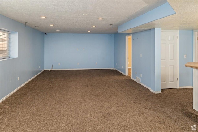 spare room featuring carpet and a textured ceiling