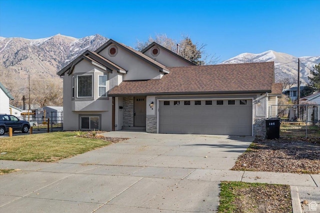 view of front of property featuring a mountain view, a front lawn, and a garage