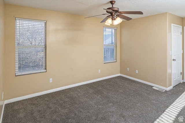carpeted empty room with ceiling fan and a textured ceiling