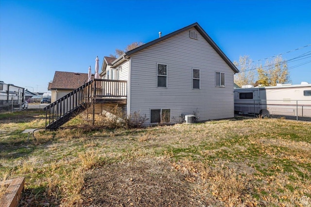 rear view of house featuring central AC and a yard