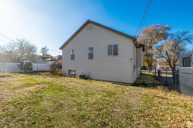 back of property featuring a yard and central AC