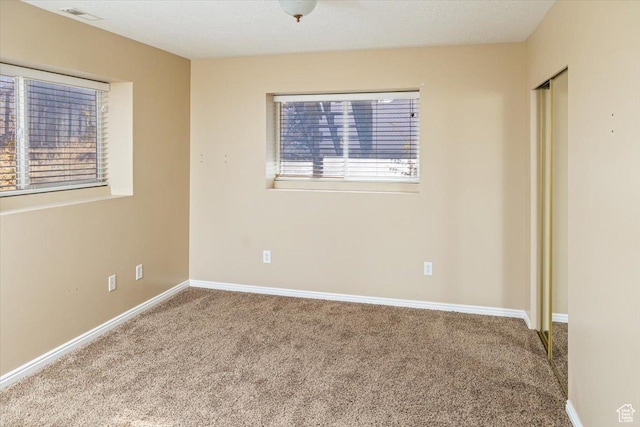 carpeted empty room with a healthy amount of sunlight