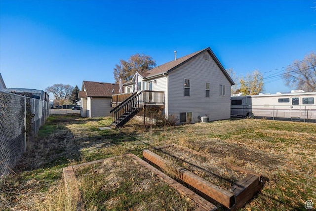 back of house with a storage unit, a deck, and central AC unit