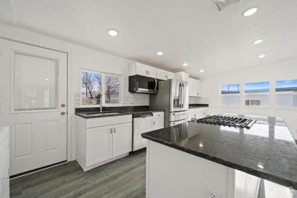 kitchen featuring white cabinets, a sink, appliances with stainless steel finishes, and a healthy amount of sunlight