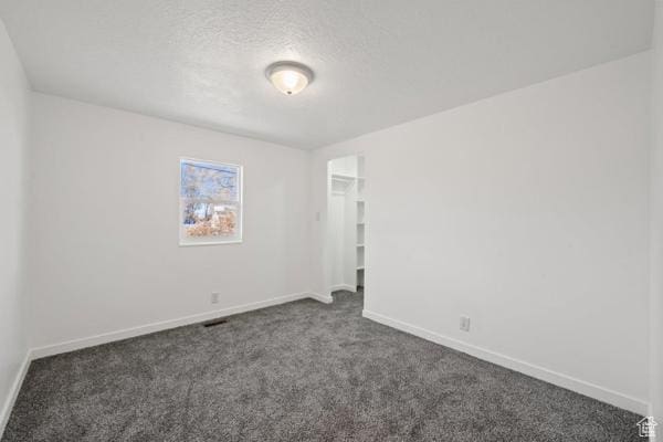 756 E 3rd St S, Ogden, UT 84404 - spare room featuring baseboards, dark colored carpet, and a textured ceiling