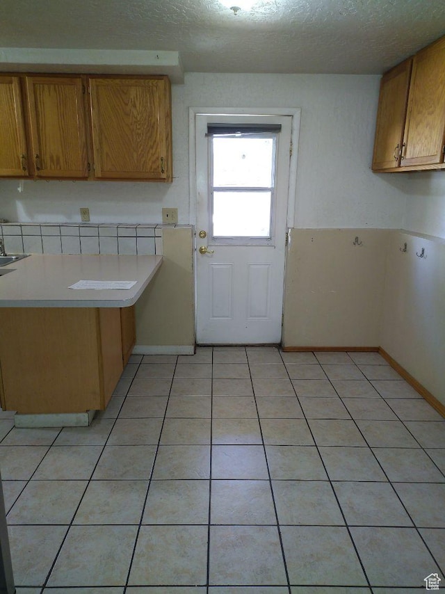 kitchen with light tile patterned floors, a textured ceiling, and sink
