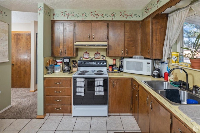 kitchen with a textured ceiling, sink, exhaust hood, and white appliances
