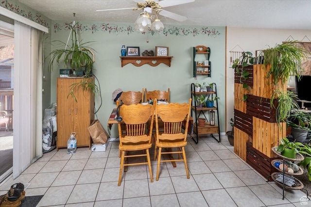 dining space featuring ceiling fan, light tile patterned floors, and a textured ceiling