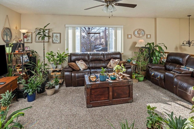living room featuring a textured ceiling, carpet floors, and ceiling fan
