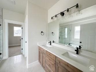308 E Prestwick Ln, Stansbury Park, UT 84074 - full bath featuring double vanity, a stall shower, plenty of natural light, and a sink
