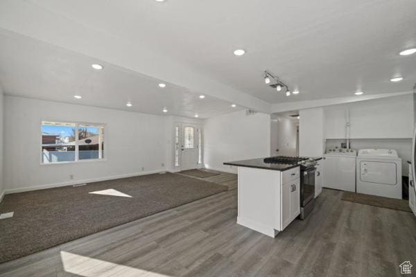 758 E 3rd St S, Ogden, UT 84404 - kitchen featuring washing machine and clothes dryer, stainless steel gas range, white cabinetry, wood finished floors, and recessed lighting