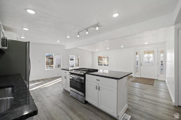 758 E 3rd St S, Ogden, UT 84404 - kitchen featuring stainless steel range with gas stovetop, freestanding refrigerator, white cabinets, wood finished floors, and recessed lighting