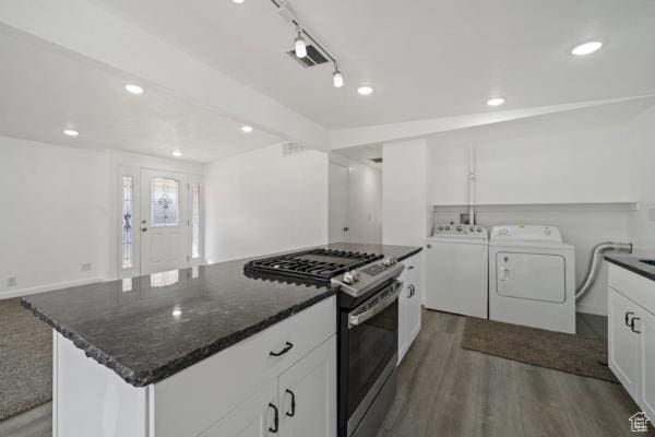 758 E 3rd St S, Ogden, UT 84404 - kitchen with stainless steel range with gas cooktop, washing machine and dryer, white cabinetry, dark wood finished floors, and dark stone countertops