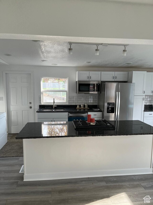 758 E 3rd St S, Ogden, UT 84404 - kitchen featuring stainless steel appliances, a sink, dark countertops, decorative backsplash, and dark wood finished floors