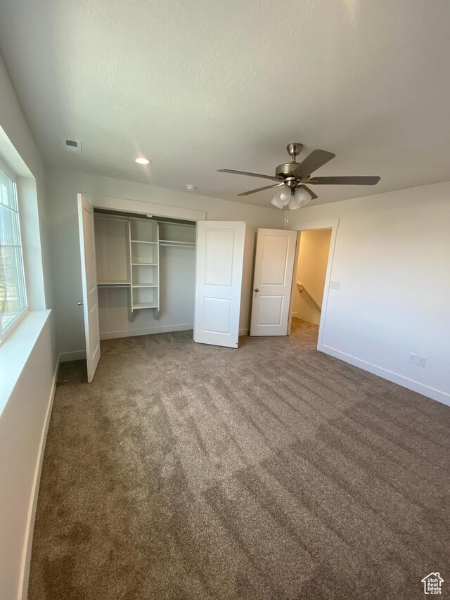 unfurnished bedroom featuring carpet flooring, a closet, and ceiling fan