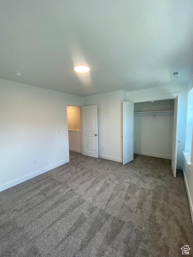 unfurnished bedroom featuring carpet and a closet