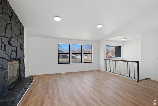 12875 S Aspen Cir, Riverton, UT 84065 - unfurnished living room featuring light hardwood / wood-style floors and a stone fireplace