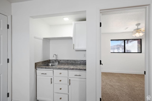 12875 S Aspen Cir, Riverton, UT 84065 - kitchen with white cabinetry, sink, ceiling fan, a textured ceiling, and carpet