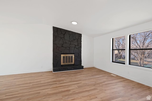 12875 S Aspen Cir, Riverton, UT 84065 - unfurnished living room with light hardwood / wood-style flooring and a stone fireplace