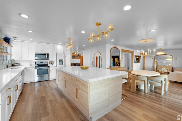 837 E 930 N, Pleasant Grove, UT 84062 - kitchen with light hardwood / wood-style flooring, white cabinets, a chandelier, and appliances with stainless steel finishes