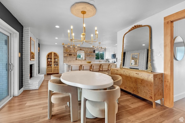 837 E 930 N, Pleasant Grove, UT 84062 - dining space with light wood-type flooring, a fireplace, and an inviting chandelier