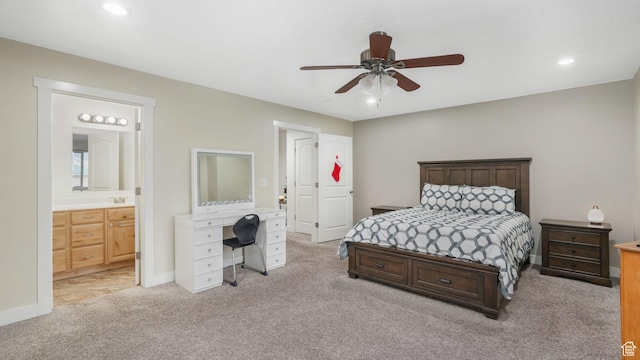 bedroom with ceiling fan, light colored carpet, and connected bathroom