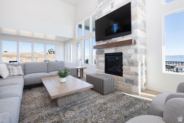 470 Lotus Dr Unit 149, Fish Haven, ID 83287 - living room with a stone fireplace, baseboards, wood finished floors, and a towering ceiling