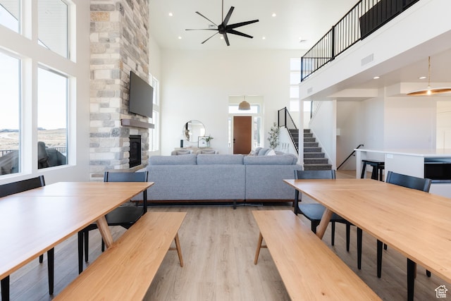 470 Lotus Dr Unit 149, Fish Haven, ID 83287 - living room with a high ceiling, a stone fireplace, light wood finished floors, a ceiling fan, and stairs