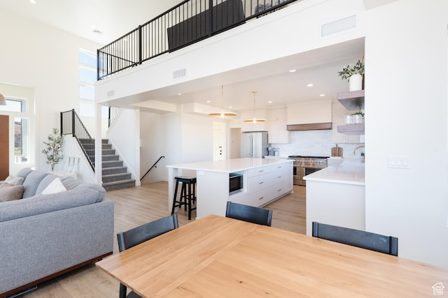 470 Lotus Dr Unit 149, Fish Haven, ID 83287 - dining room with light wood finished floors, a towering ceiling, stairway, and recessed lighting