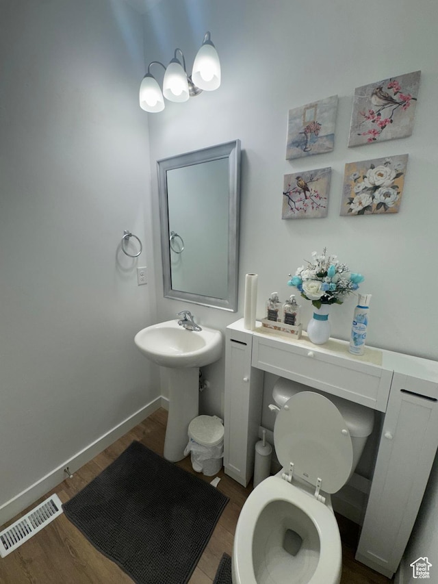bathroom with hardwood / wood-style flooring and toilet