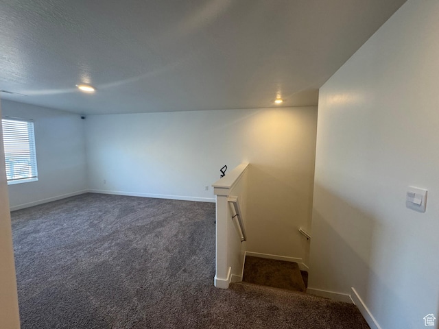 spare room featuring dark carpet