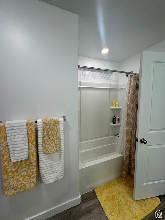 bathroom with wood-type flooring and shower / tub combo with curtain