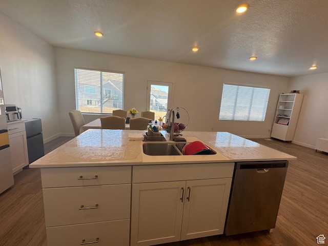 kitchen with stainless steel dishwasher, a kitchen island with sink, a healthy amount of sunlight, and sink