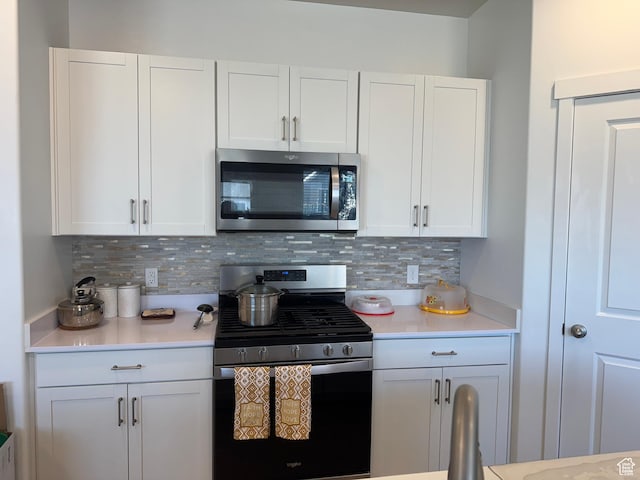 kitchen featuring appliances with stainless steel finishes, backsplash, and white cabinetry