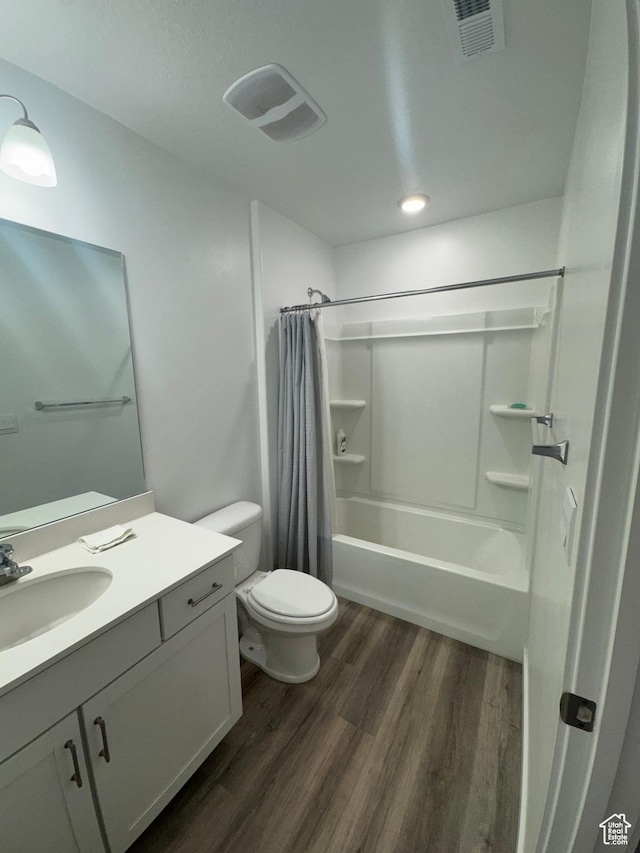 full bathroom with hardwood / wood-style floors, vanity, toilet, and shower / bath combination with curtain