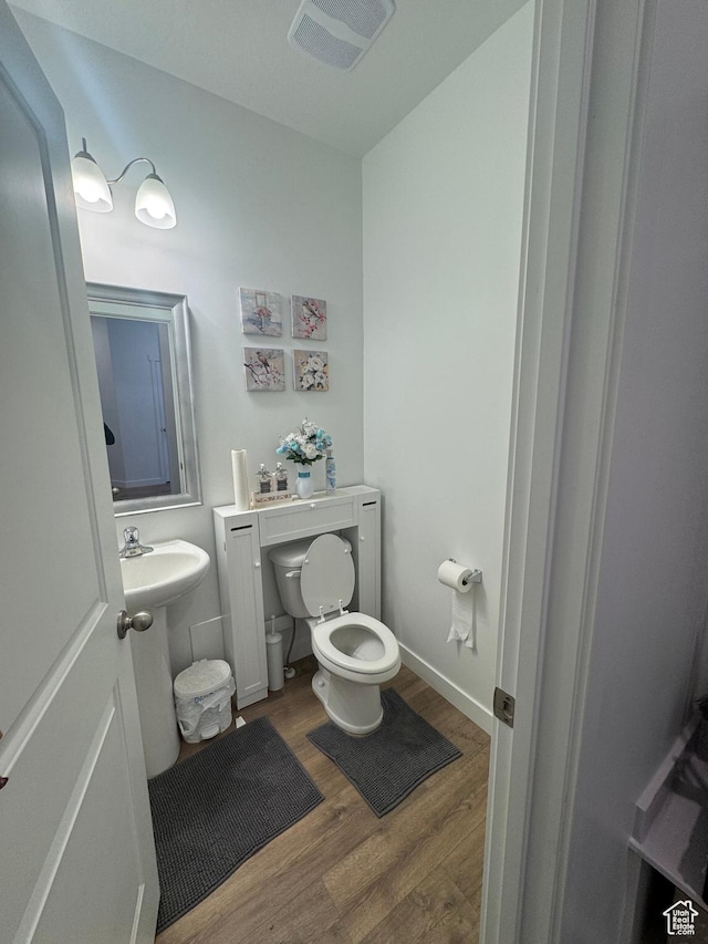 bathroom featuring hardwood / wood-style flooring and toilet