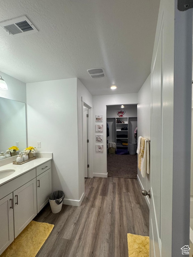 bathroom featuring hardwood / wood-style floors, vanity, and a textured ceiling