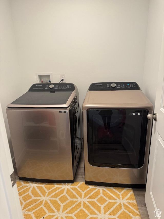 washroom with washer and dryer and wood-type flooring